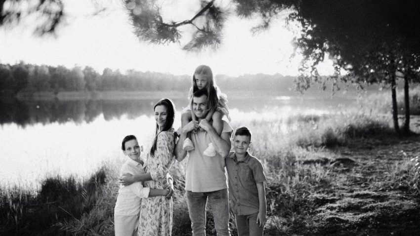 A joyful family enjoying time by the lake in a serene setting.